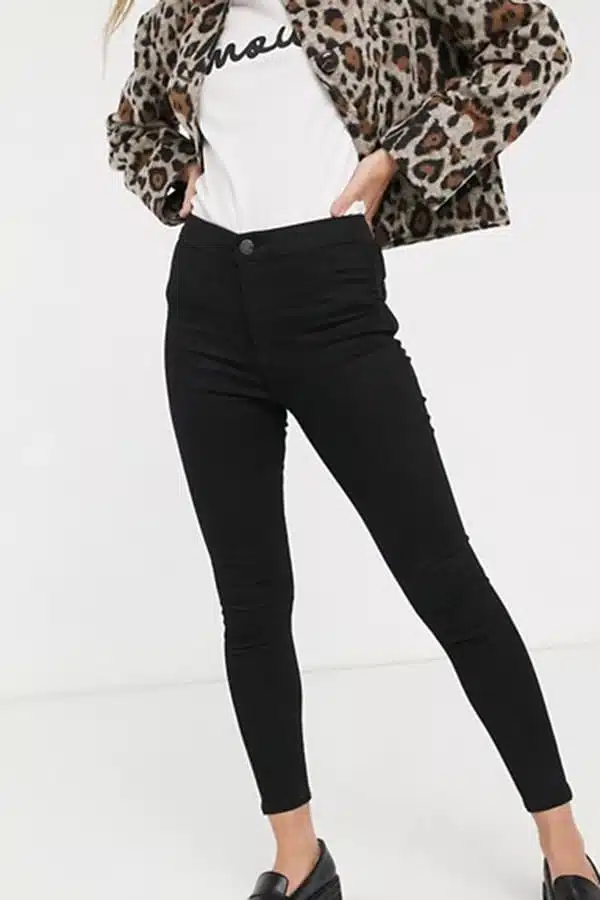 Waist-down view of model wearing black skinny jeans for petites.