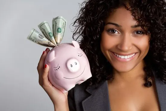 Adult smiles while holding piggy bank showing she knows how to save money.