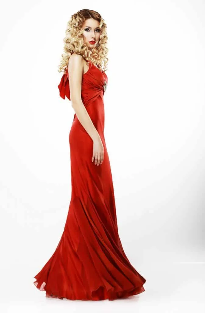Luxury. Full Length of Elegant Lady in Red Satiny Dress. Frizzy Blond Hair