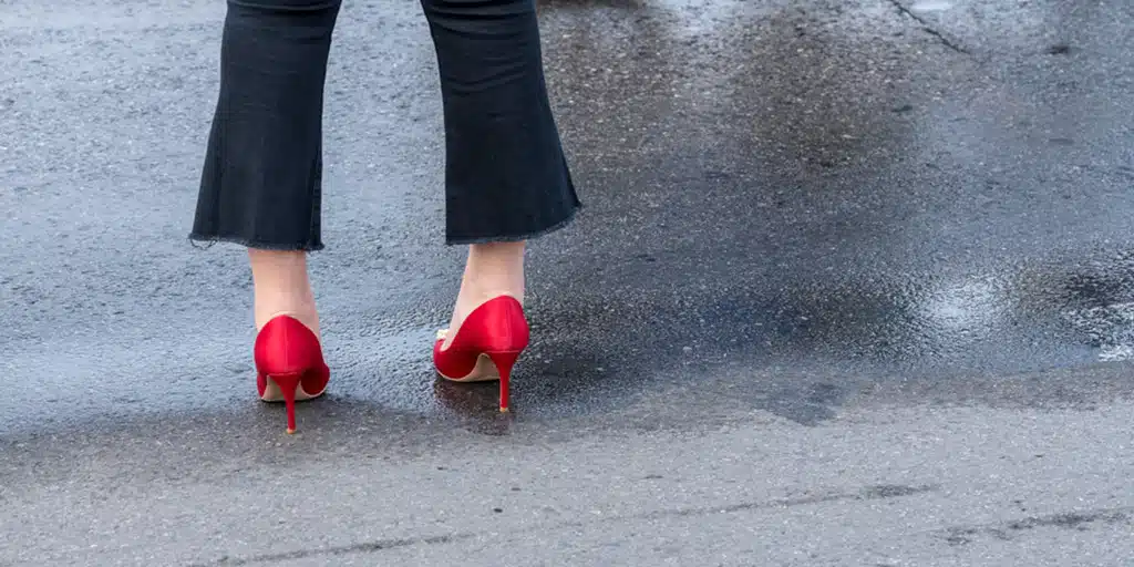 Woman wearing flared jeans and red heels