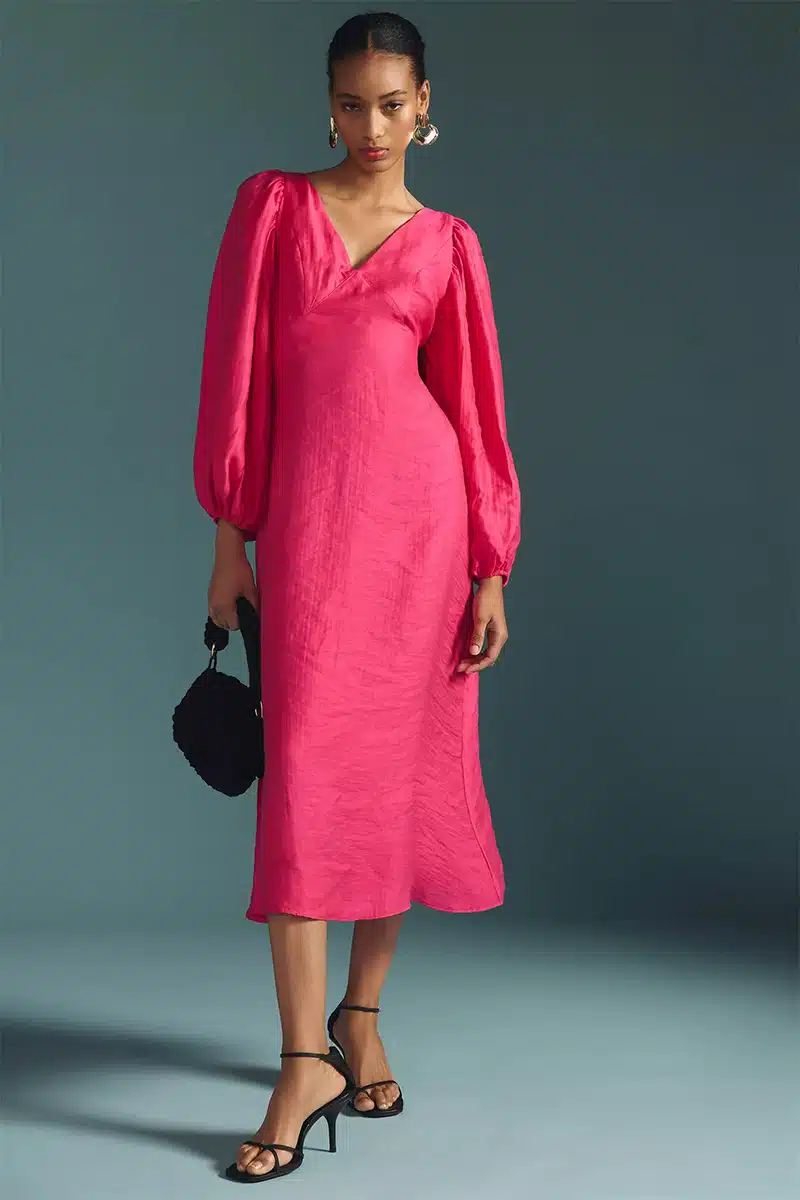 Bright pink high school reunion dress with v-neck, puff sleeves, and midi length. 