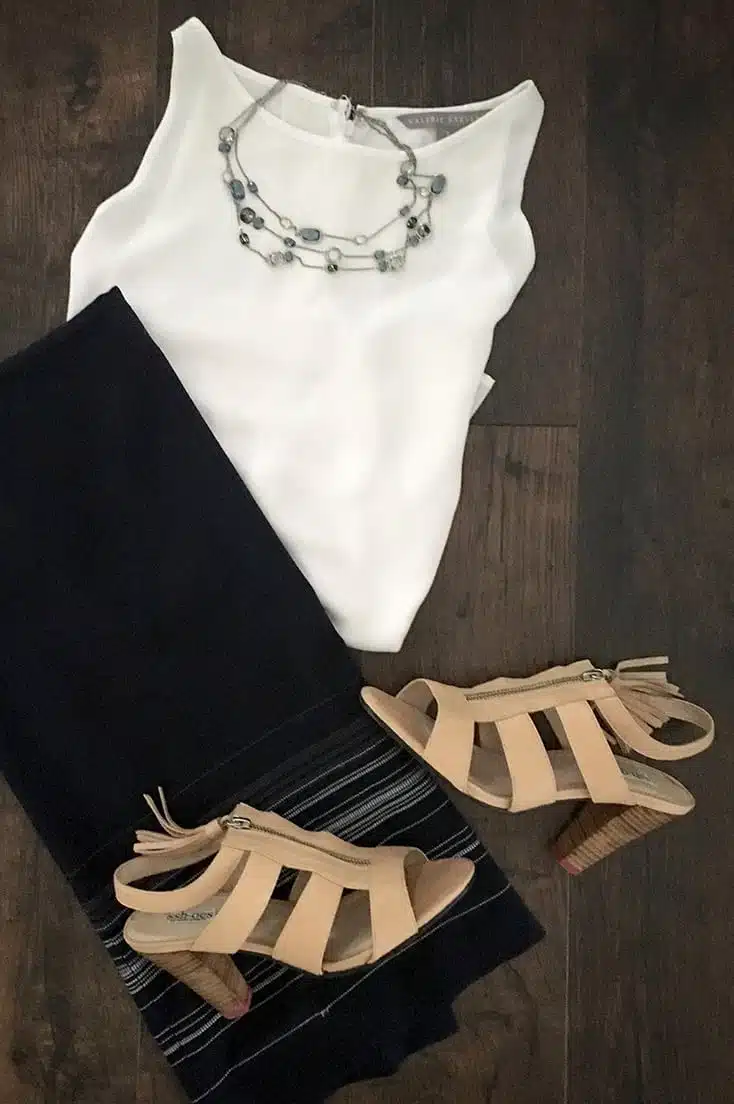 Sshoes are the solution to loud heels. Here, they're styled with a midi skirt, white blouse and statement necklace.