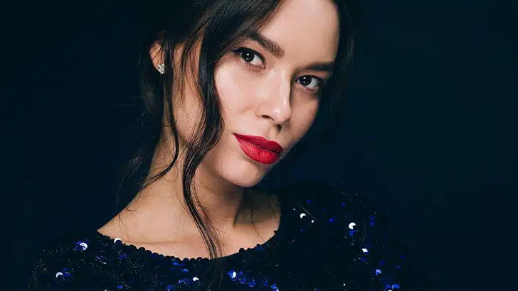 Close up of woman wearing red lipstick and blue sequin dress.