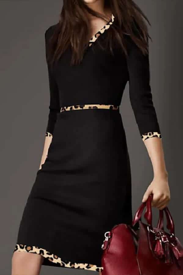 Close-up of model wearing black dress with leopard trim.