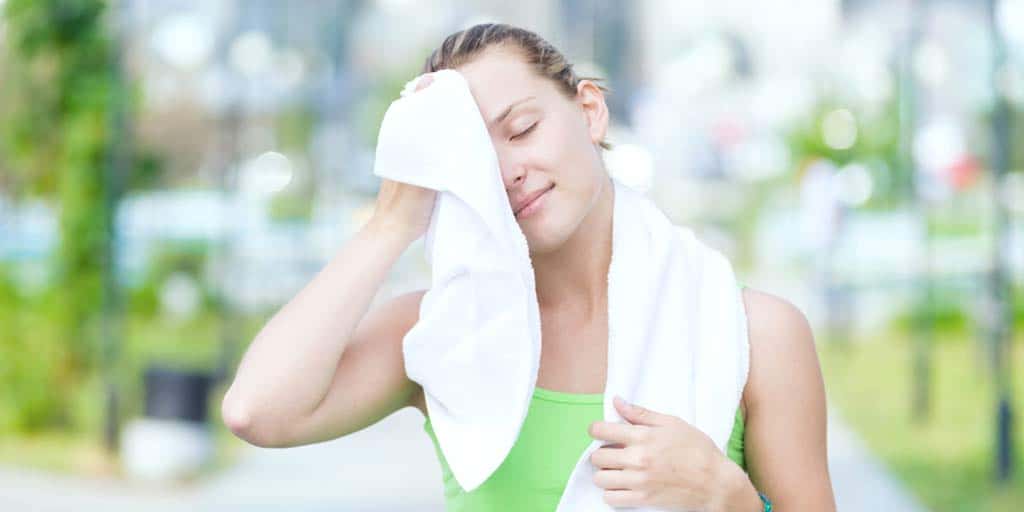 Woman holding towel to her head after hard workout