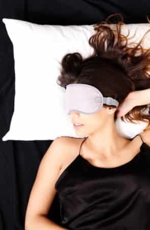 Woman sleeping in bed with eyemask
