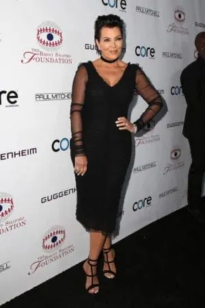 Kris Jenner on the red carpet wearing black evening dress with sheer sleeves
