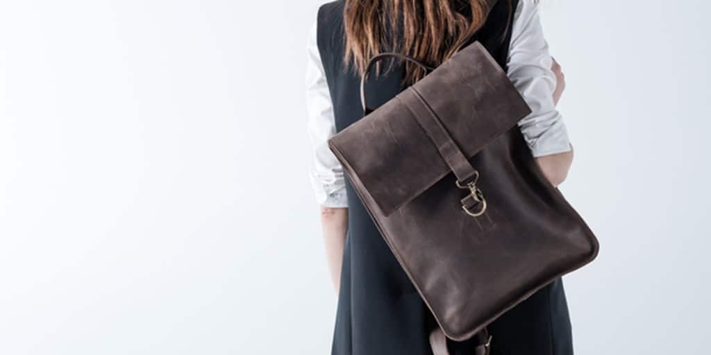 Woman wearing brown leather backpack