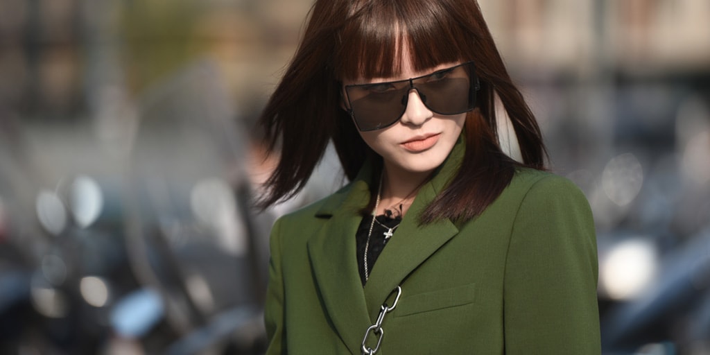 Woman on the street wearing fashion sunglasses and green suit