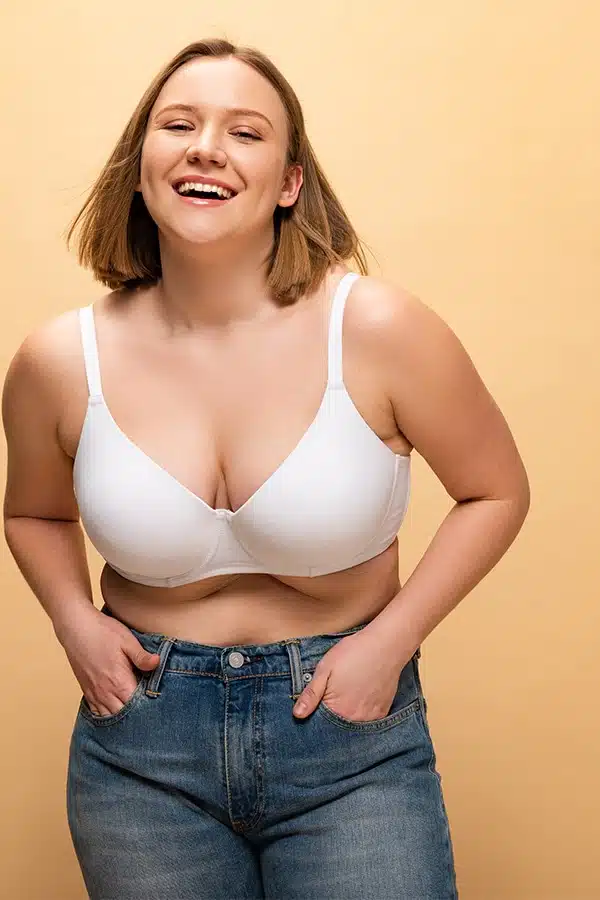 Smiling woman wearing bra and jeans