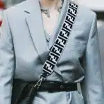 Woman on street wearing blazer with crossbody bag.
