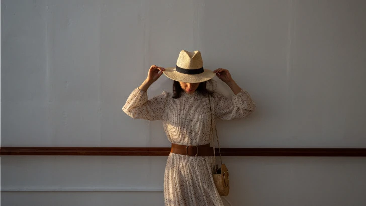 Woman wearing hat with long sleeve midi dress.