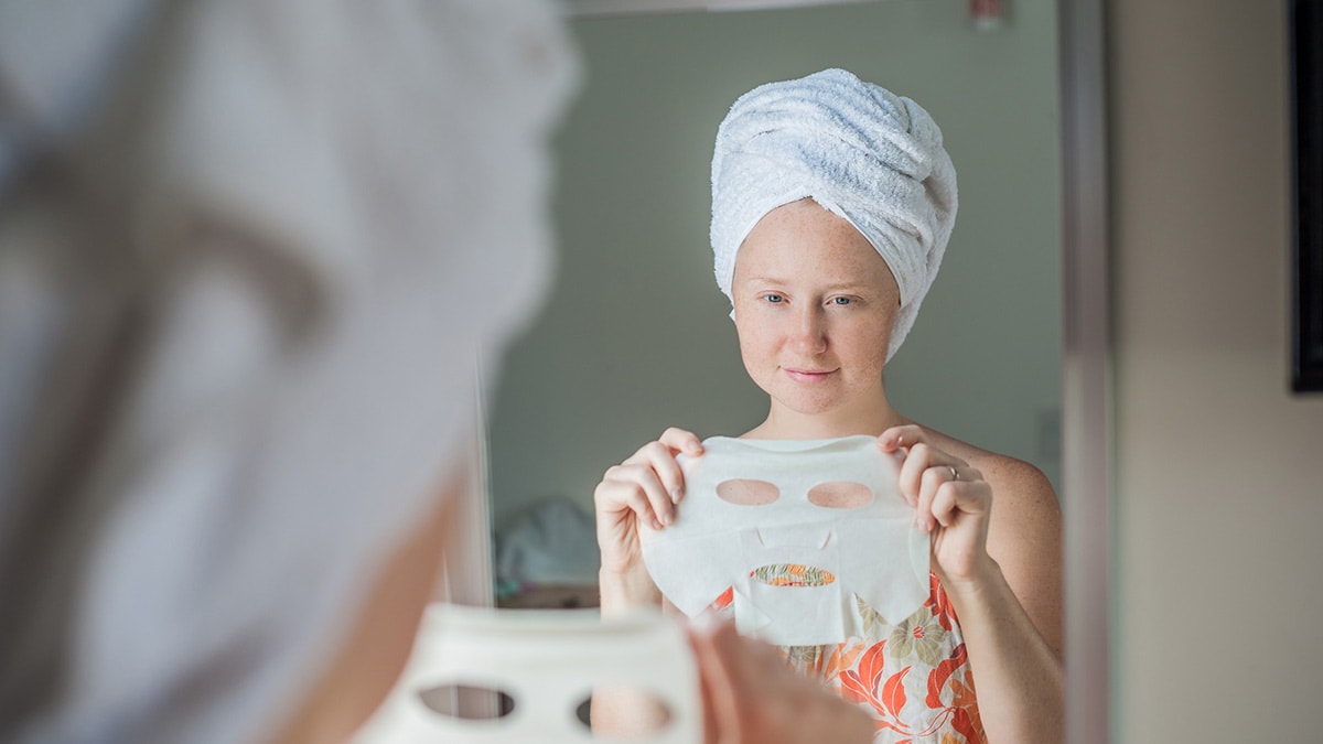 Woman holding sheet masks a must-have summer beauty hack