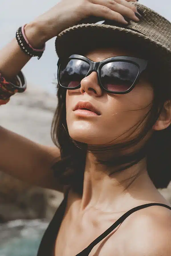 Close up of stylish woman wearing sunglasses and hat.