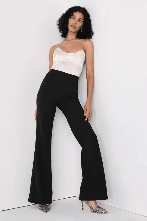 Model wears black, high waisted pants that are suited for the woman with a long torso.