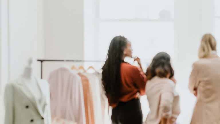 Blurred shot from behind of women in a boutique store shopping sample sale.