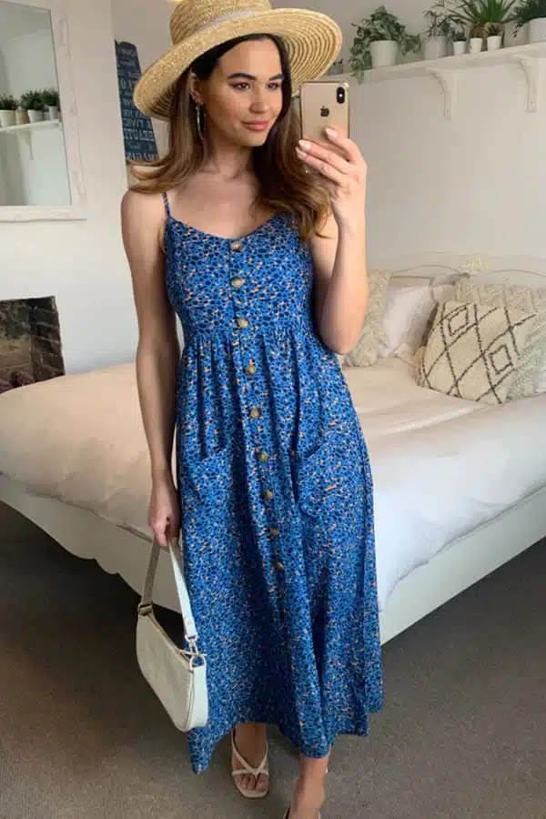 Model taking selfie while wearing blue leopard-print beach dress.