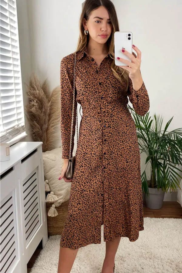 Model wearing button-down shirt dress with leopard pattern.