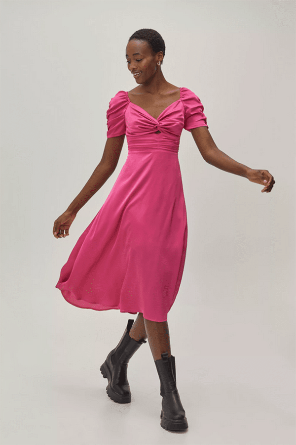 Smiling model wears hot pink dress with A-line skirt.