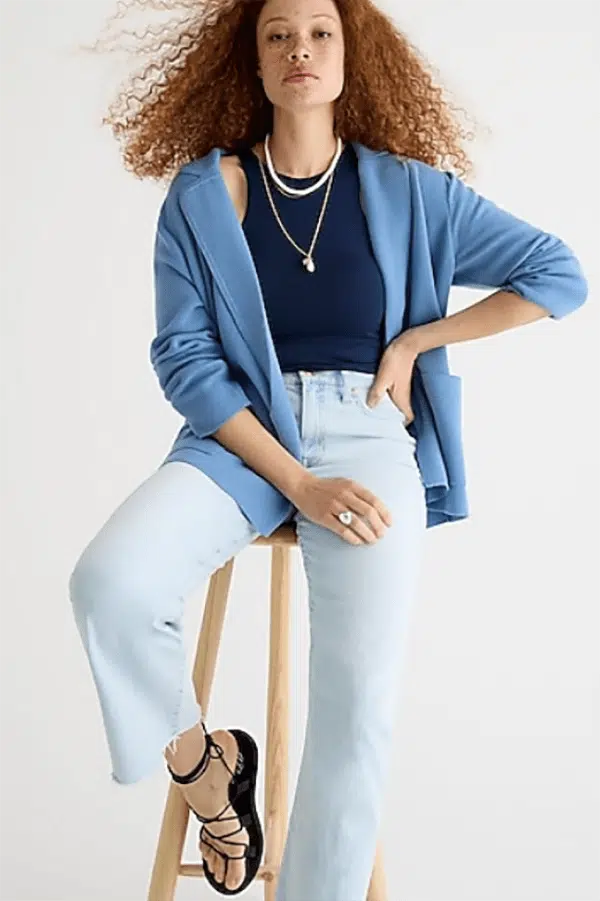 Model wears jeans, tank top, and blue sweater blazer.