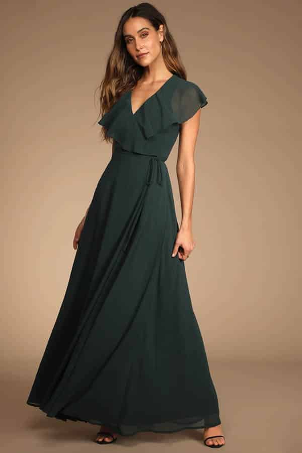 Model wears floor-length party dress with flutter sleeves.
