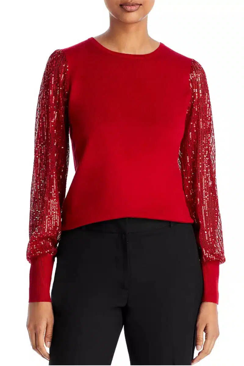 Close up of woman wearing a sequin top with blouson sleeves.