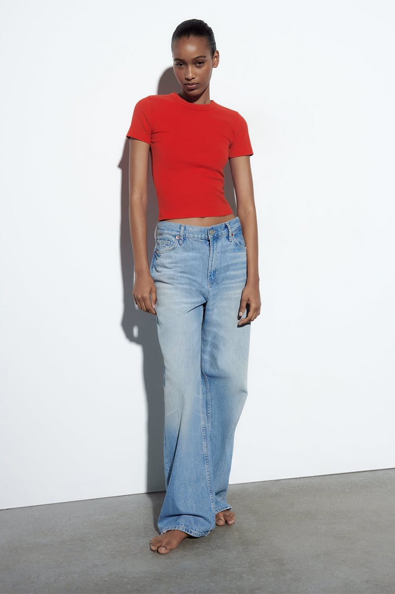 Model wears red t-shirt from Zara with jeans.