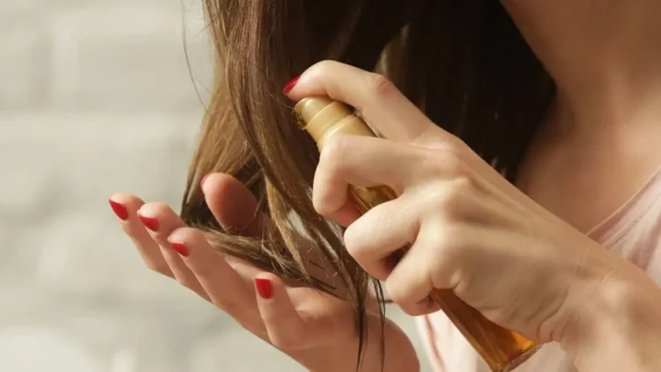 Close-up of woman applying hair product to hair.